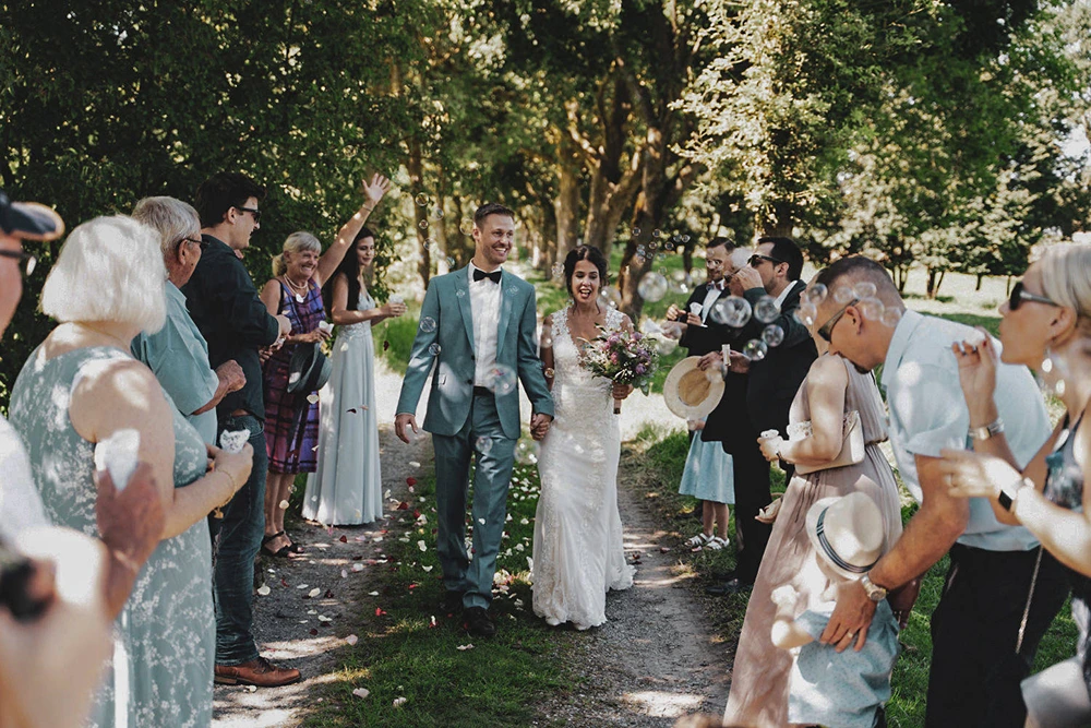 Hochzyt Foto mit Gästen im Freien – Brautpaar und Seifenblasenmoment bei hochzytfotograf.com